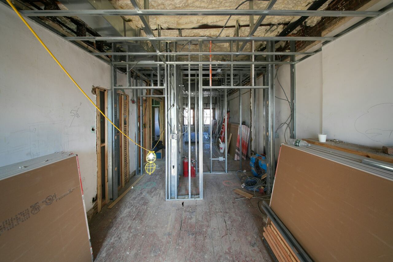 Ruimte met een metalen structuur voor gyprocwanden en gipsplaten tegen de muur.